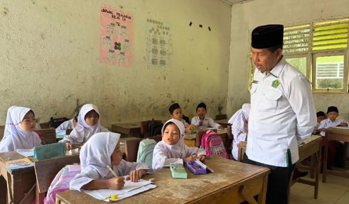 Kepala Kantor Kementerian Agama Kabupaten Padang Lawas Dr. Kasman MA menguji kemampuan membaca dan berhitung siswa Madrasah Ibtidaiyah saat kunjungan monitoring.
