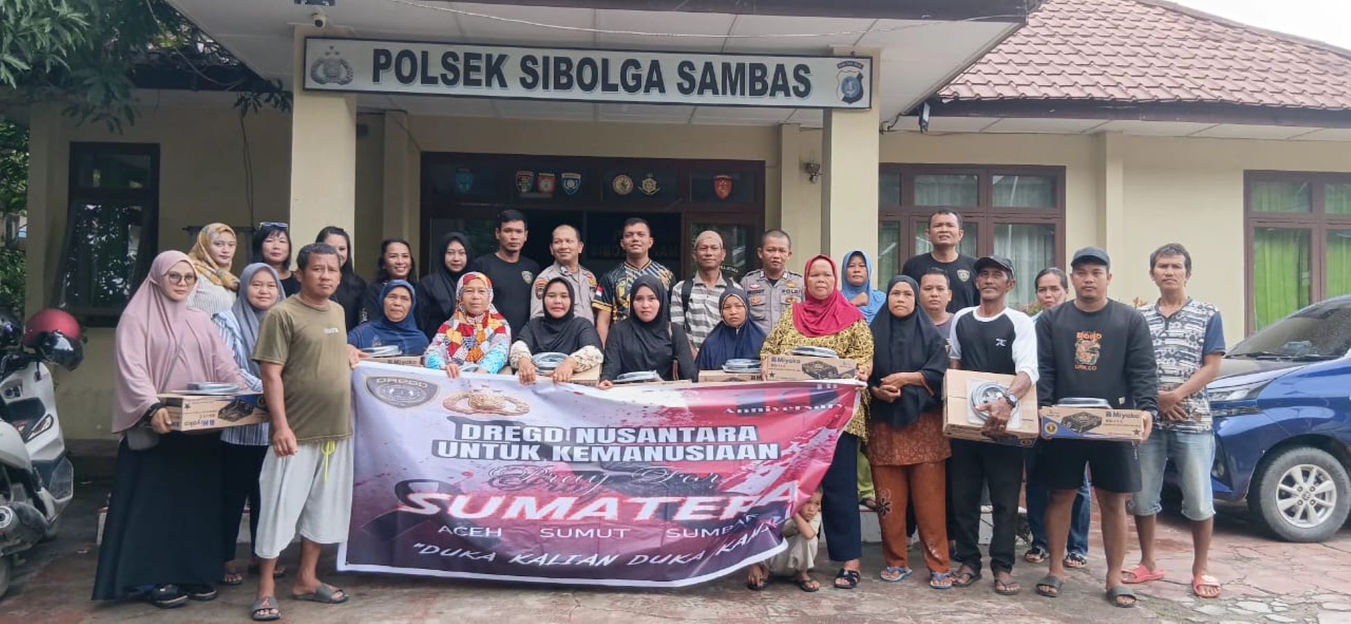 Personel Dregd Nusantara Polres Sibolga foto bersama usai menyerahkan bantuan kepada korban bencana alam di Kota Sibolga.