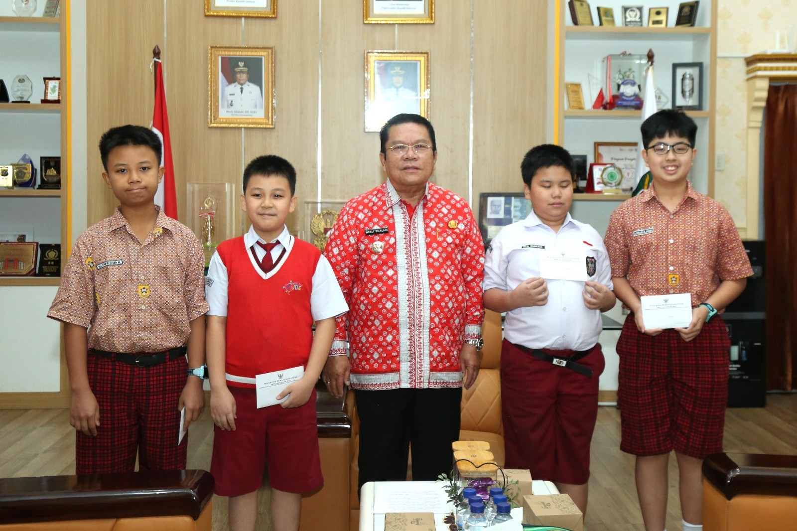 Wali Kota Pematangsiantar Wesly Silalahi berfoto bersama siswa-siswa berprestasi tingkat nasional dan internasional di ruang kerjanya.