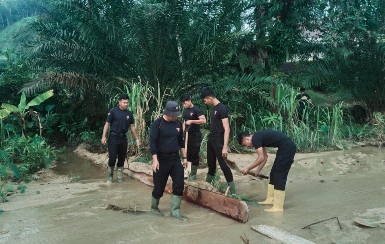 Personel Batalyon C Satuan Brimob Polda Sumatera Utara melakukan pengamanan dan pengaturan lalu lintas di akses jalan darurat Desa Garoga, Batang Toru, Tapanuli Selatan.