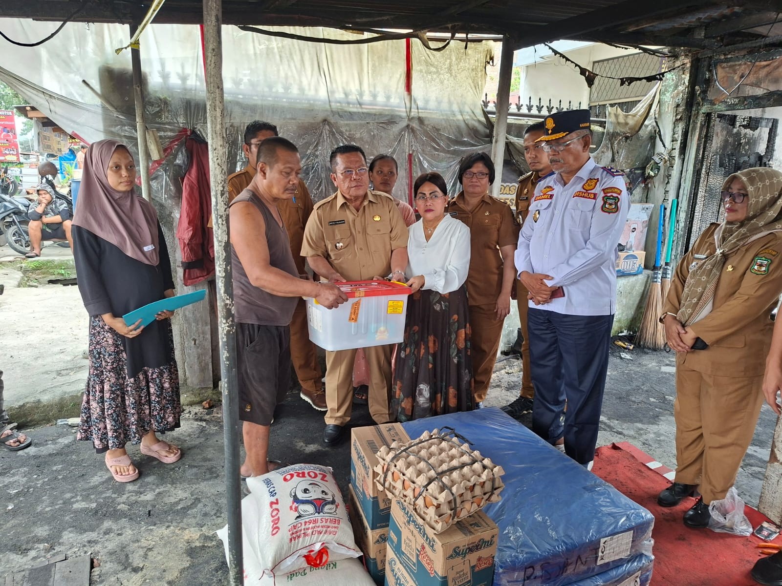 Wali Kota Pematangsiantar Wesly Silalahi didampingi Ketua TP PKK Liswati Wesly Silalahi menyerahkan bantuan kepada korban kebakaran rumah.