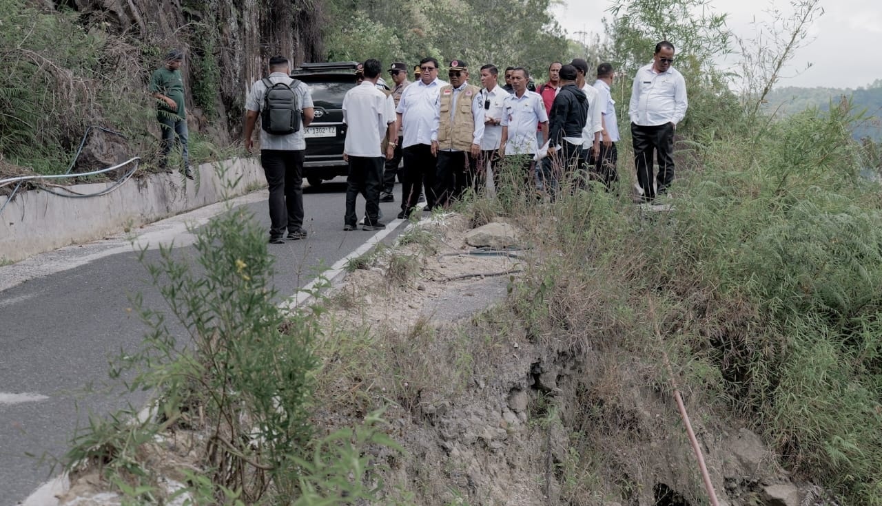 Teks Foto Bupati Simalungun Anton Achmad Saragih didampingi jajaran OPD meninjau kondisi jalan longsor di Kecamatan Haranggaol Horison.