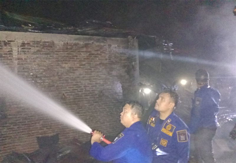 Petugas damkar sedang berjibaku memadamkan api.