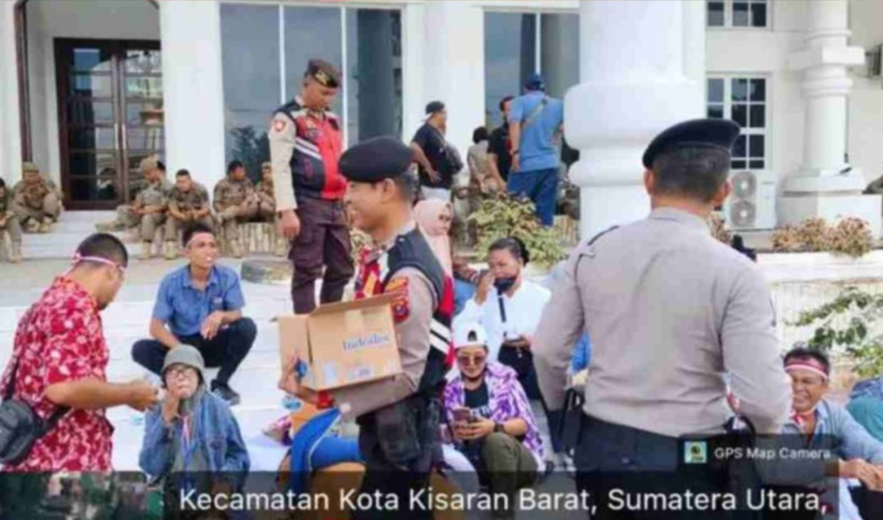Personel Sat Samapta Polres Asahan membagikan air mineral kepada massa aksi Poktan Karya Tani saat pengamanan unjuk rasa di Kantor Bupati Asahan.