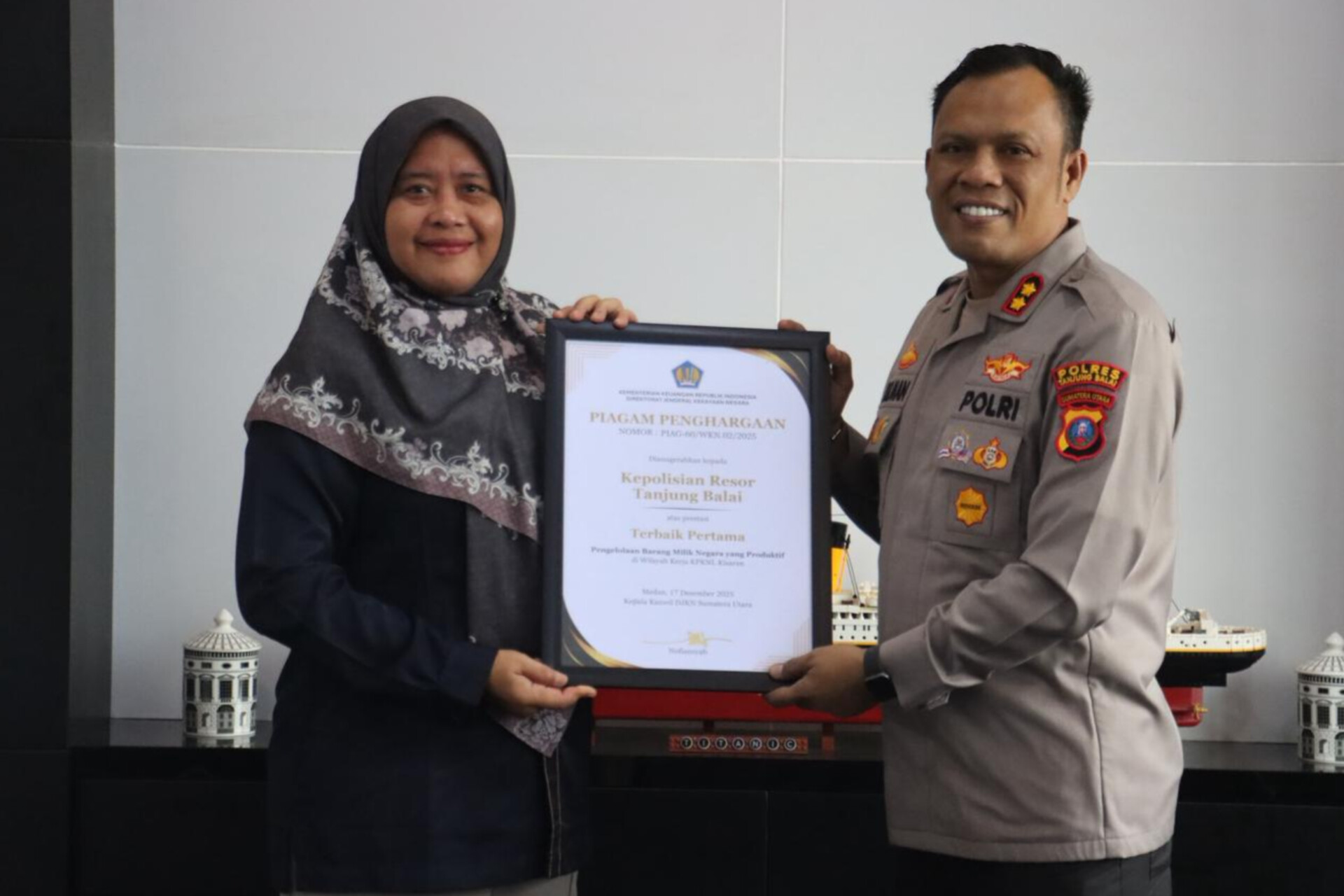 Kapolres Tanjungbalai AKBP Welman Feri menerima penghargaan Pengelolaan Kekayaan Negara Awards 2025 dari Kepala KPKNL Kisaran.