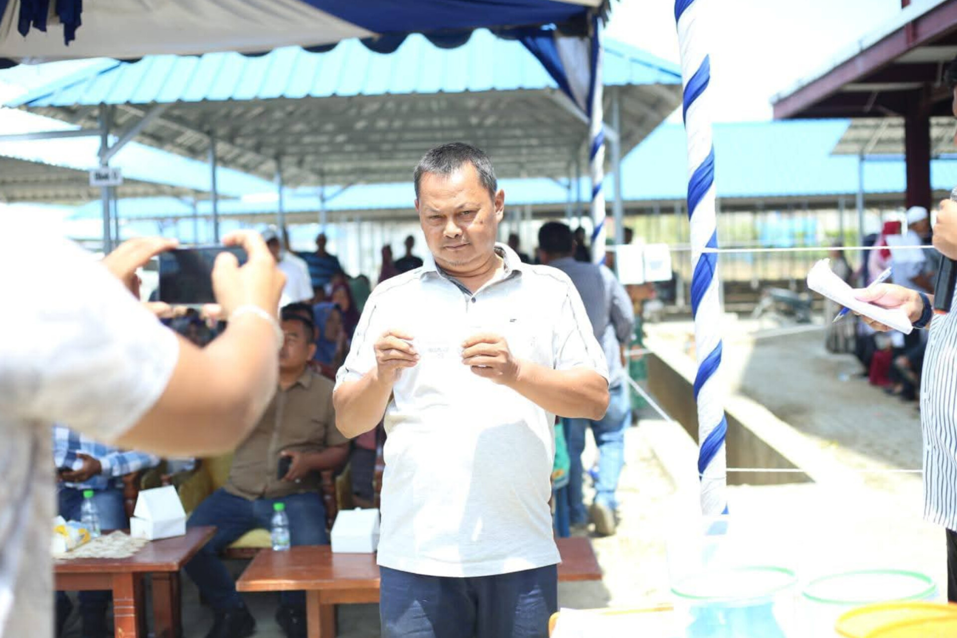 Pedagang Pasar Baru Panyabungan menunjukkan nomor undian los yang diterimanya saat pengundian oleh Pemkab Madina.
