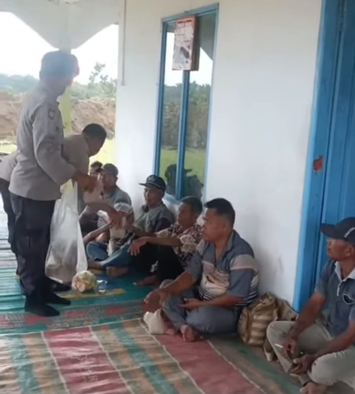 Kapolsek Aek Natas Iptu Sofyan Tampubolon bagikan nasi kepada warga terdampak eksekusi lahan di Padang Halaban.