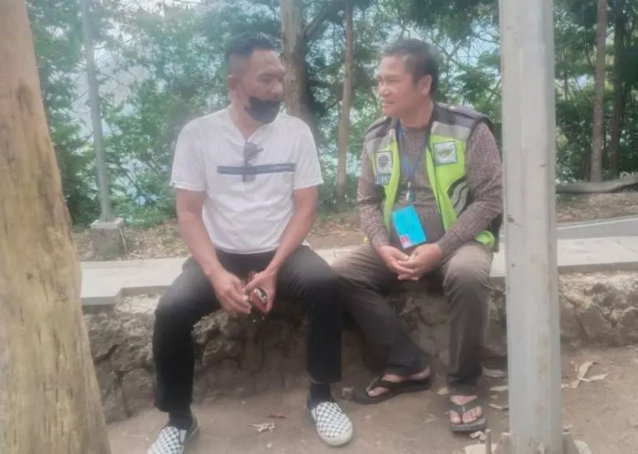 Petugas parkir kawasan wisata Menara Pandang Tele, Kabupaten Samosir, berbincang dengan praktisi hukum Boris Situmorang (kaos putih) terkait penghentian kontrak kerja.
