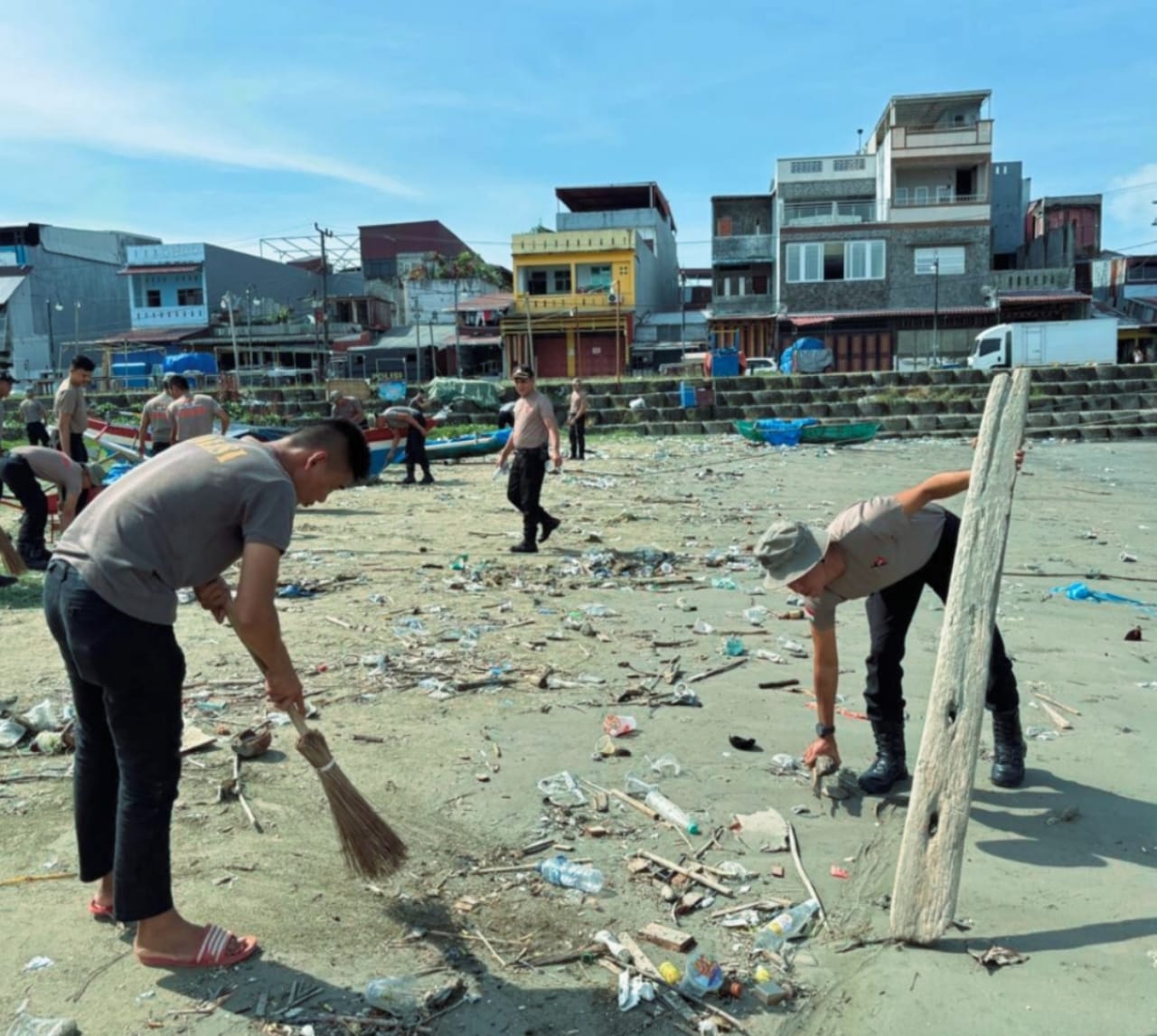 Personel Kompi 4 Batalyon C Sat Brimob Polda Sumatera Utara membersihkan sampah di kawasan Pantai Taman Kota Gunungsitoli, Selasa (3/2/2026).
