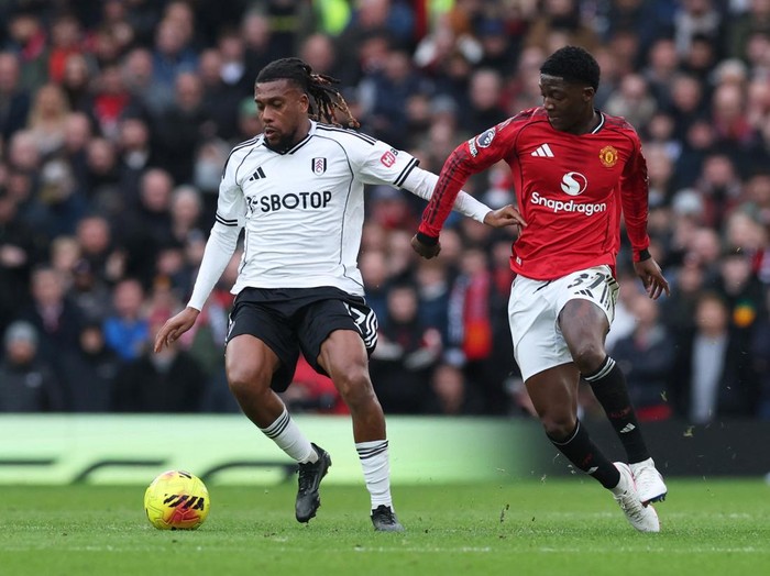 Alex Iwobi (kiri) berduel dengan Kobbie Mainoo pada laga Manchester United vs Fulham di Old Trafford, Minggu (1/2).