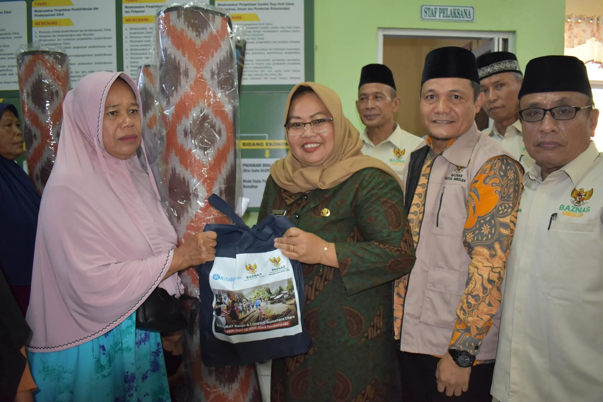 Camat Sibolga Kota Zainab menyerahkan bantuan Paket Keluarga Muslimah kepada warga korban bencana alam di Kota Sibolga.