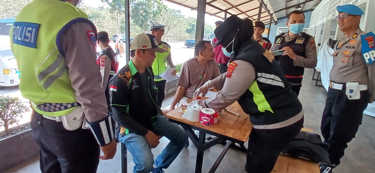 Petugas Ditlantas Polda Sumut melakukan ramp check dan tes urin terhadap sopir truk dan travel dalam Operasi Keselamatan Toba 2026.