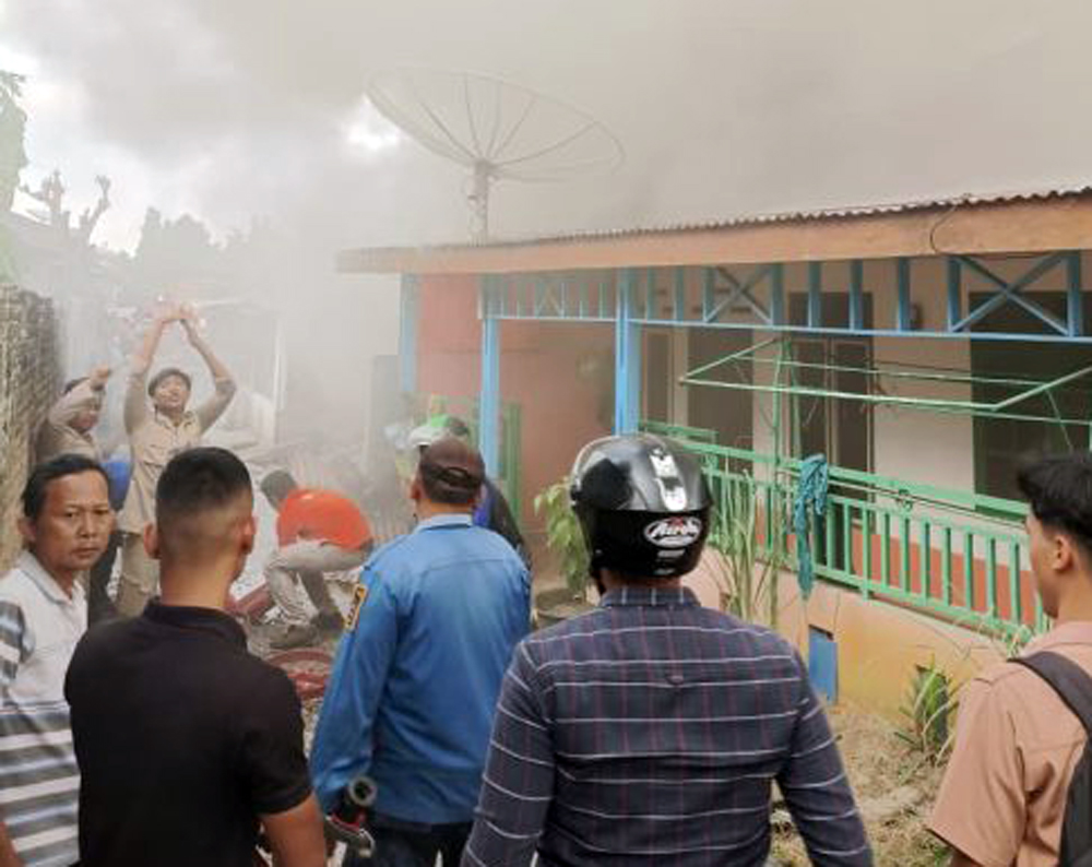 Petugas pemadam kebakaran berupaya memadamkan api yang membakar rumah warga di belakang SMAN 3 Pematangsiantar.
