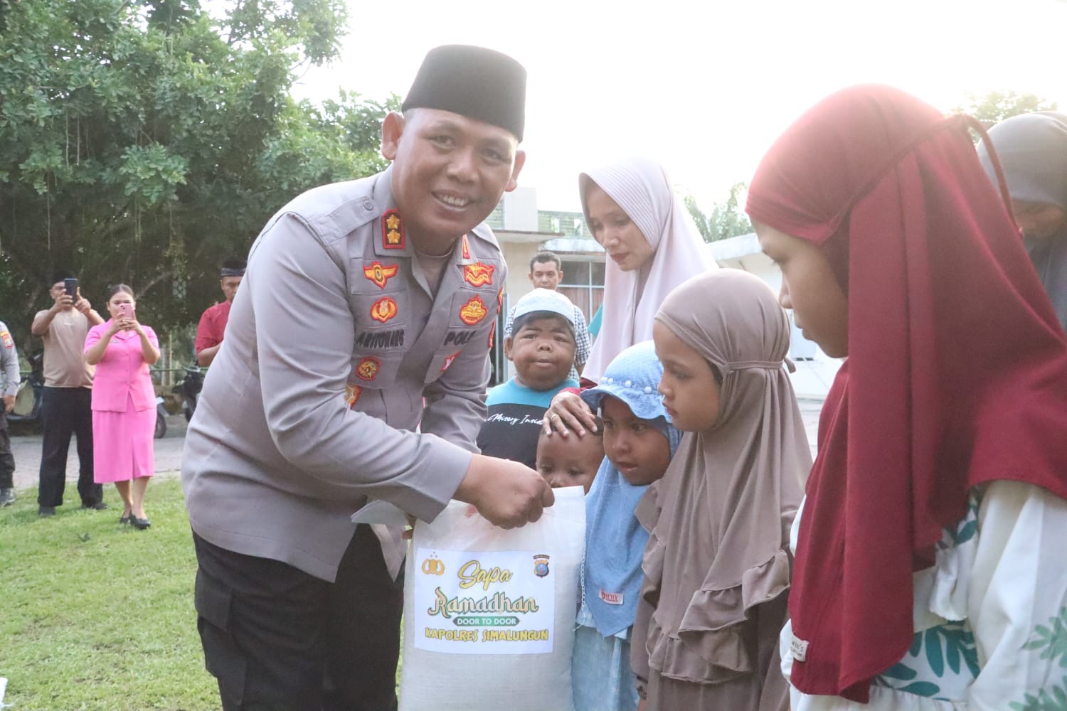 Kapolres Simalungun AKBP Marganda Aritonang menyerahkan santunan kepada anak yatim dalam program Sapa Ramadan Door to Door di Dolok Ilir.