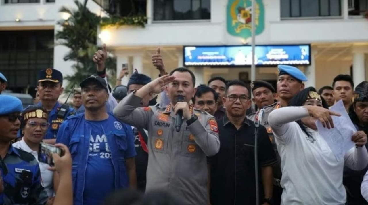 Kapolrestabes Medan Jean Calvijn Simanjuntak berdiri di tengah massa aksi dan memimpin doa bersama saat demonstrasi terkait surat edaran Wali Kota Medan, Jumat (27/02/2026).