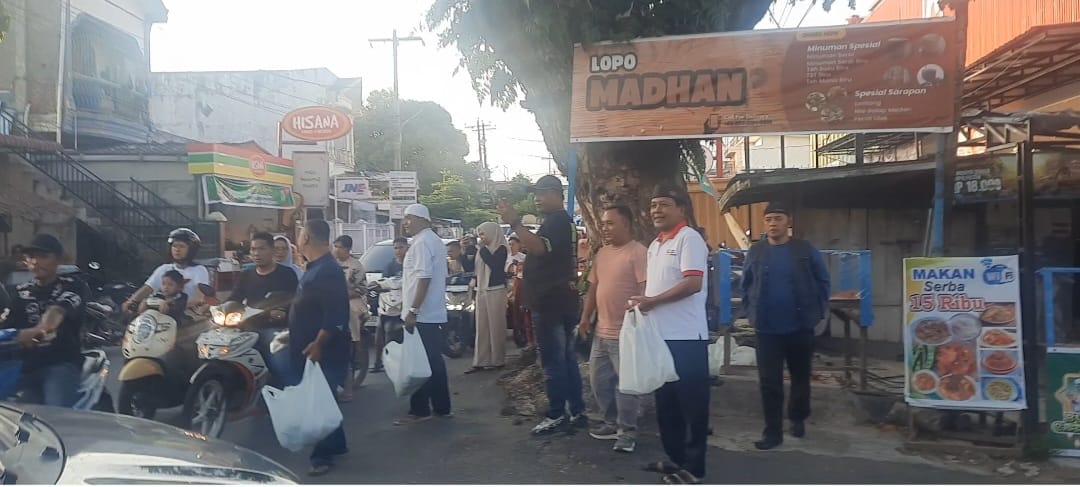 Persaudaraan Jurnalis Lopo Madan membagikan ratusan takjil kepada pengguna jalan di simpang empat Jalan Kenanga, Kecamatan Padangsidimpuan Utara, Minggu (1/3/2026). 