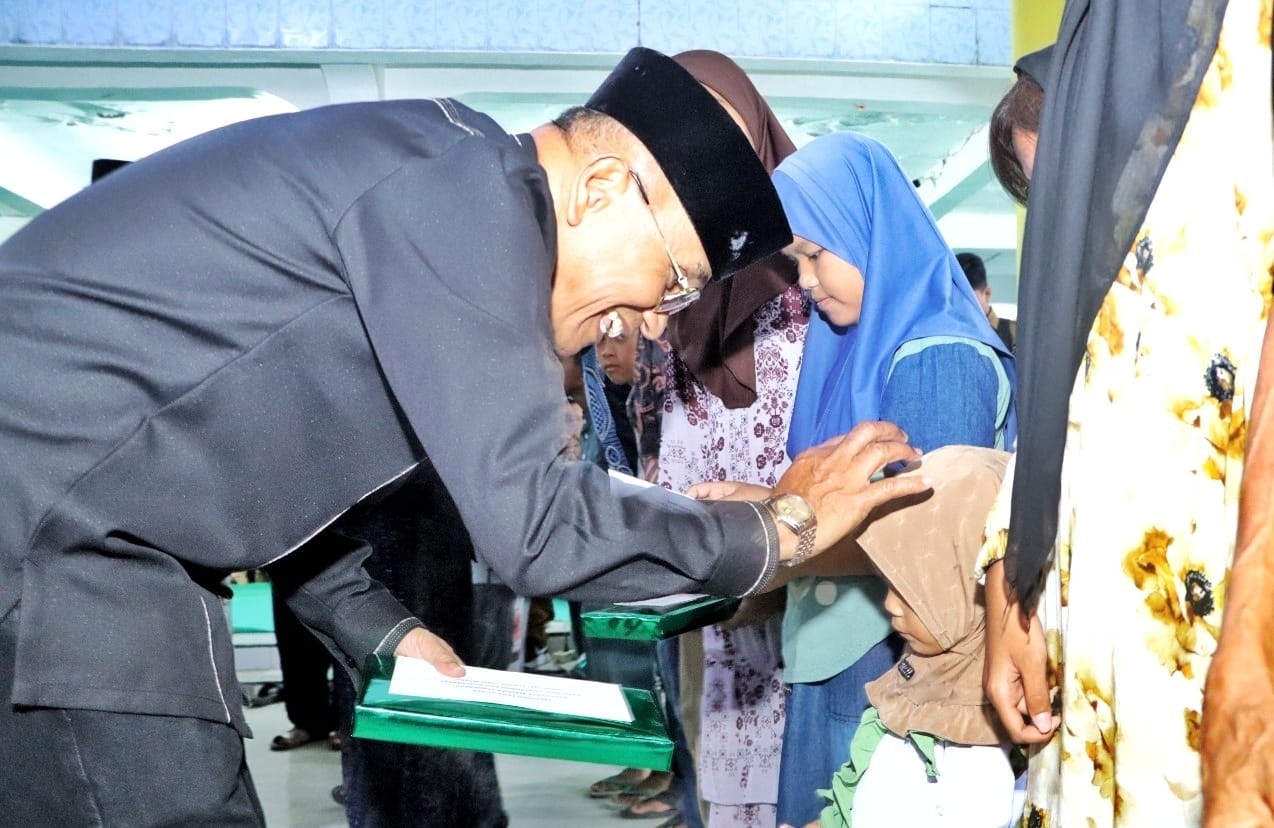 Bupati Simalungun, Anton Achmad Saragih, menyerahkan santunan kepada anak yatim saat buka puasa bersama masyarakat di Masjid Al Hidayah, Bosar Maligas, Senin (2/3).