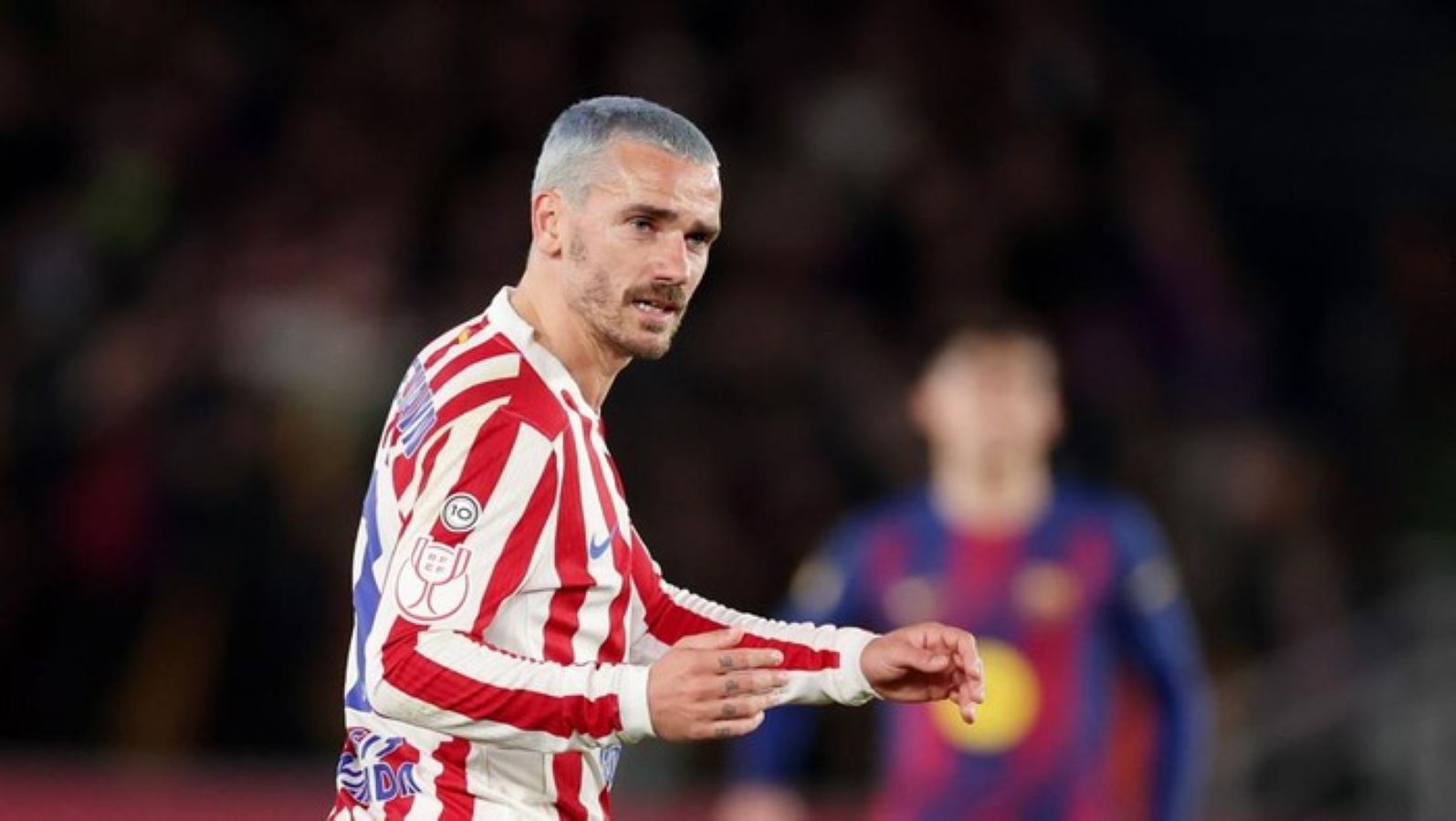 Antoine Griezmann merayakan kelolosan Atletico Madrid ke final Copa del Rey di Camp Nou, dengan pemain Barcelona tampak kecewa di belakangnya.