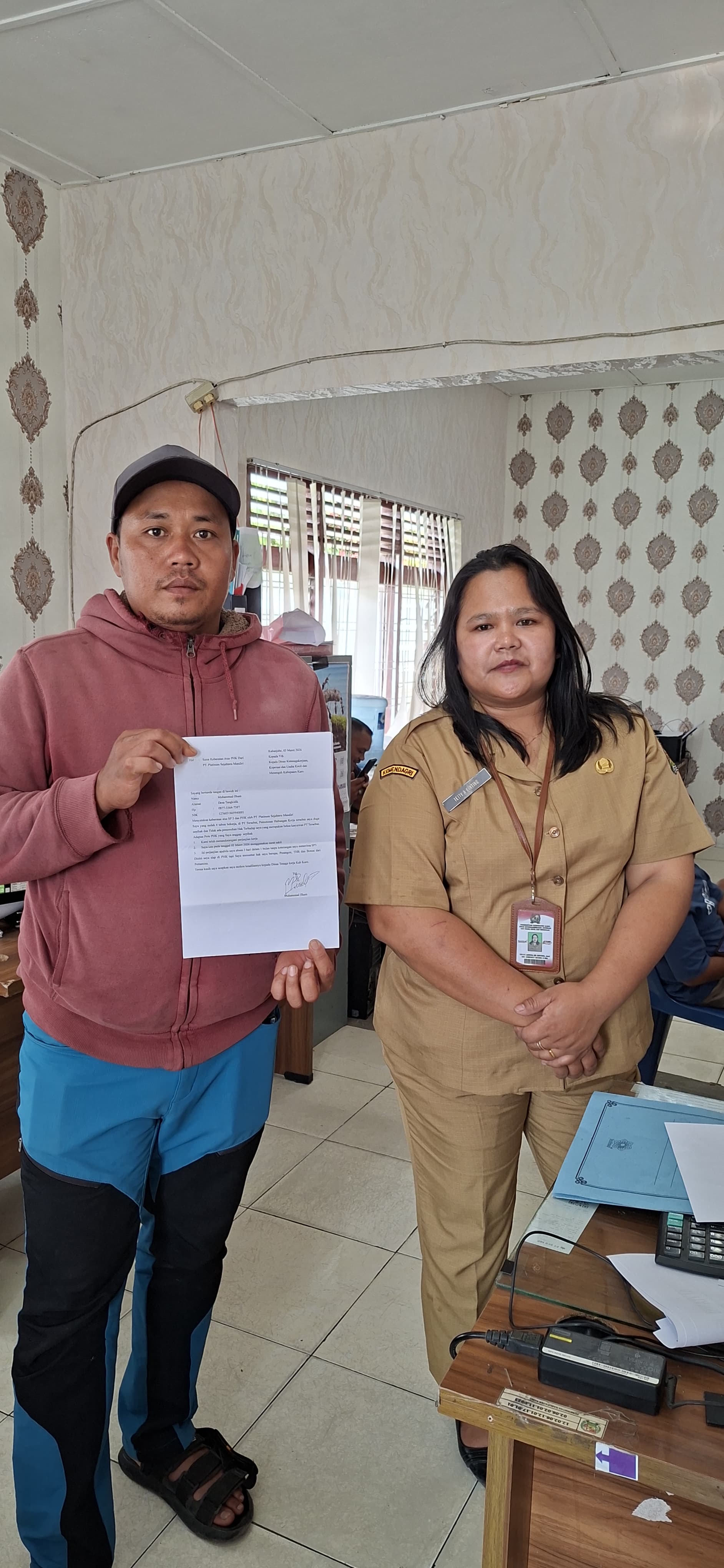 Muhammad Ilham menunjukkan surat pengaduan ke Disnaker Karo terkait PHK dari PT Platinum Sejahtera Mandiri, didampingi istrinya di Kabanjahe.