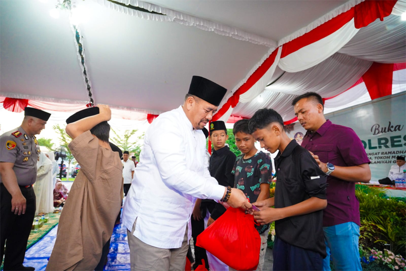 Bupati Bupati Batu Bara H Baharuddin Siagian menyerahkan santunan pada acara buka puasa bersama Polres Batubara.