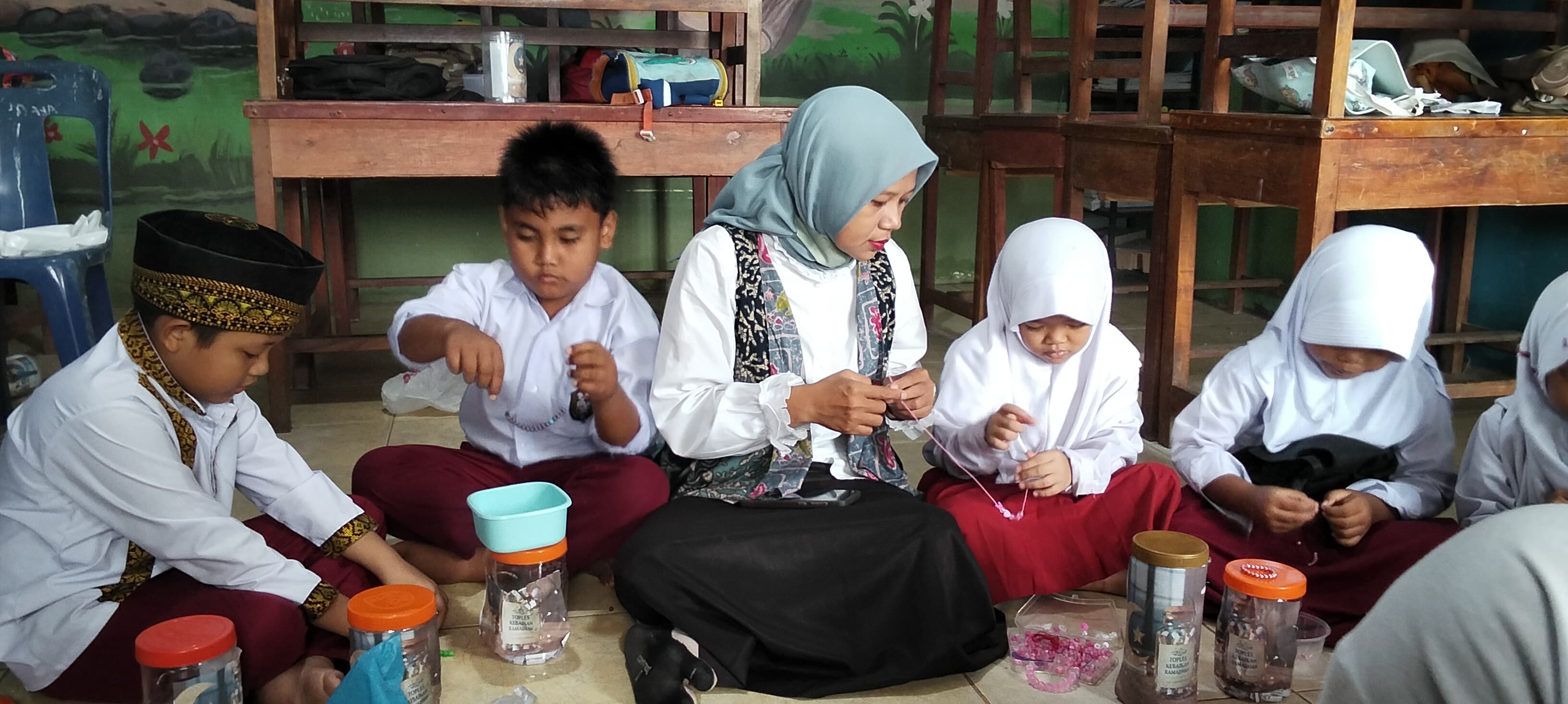 Hotma Wulansari Sitohang, guru kelas I UPT SDN 30 Pasar Lapan, menunjukkan media pembelajaran TOKEDAN LINU (Toples Kebaikan Ramadan Literasi Numerasi) yang digunakan untuk menanamkan nilai kebaikan.