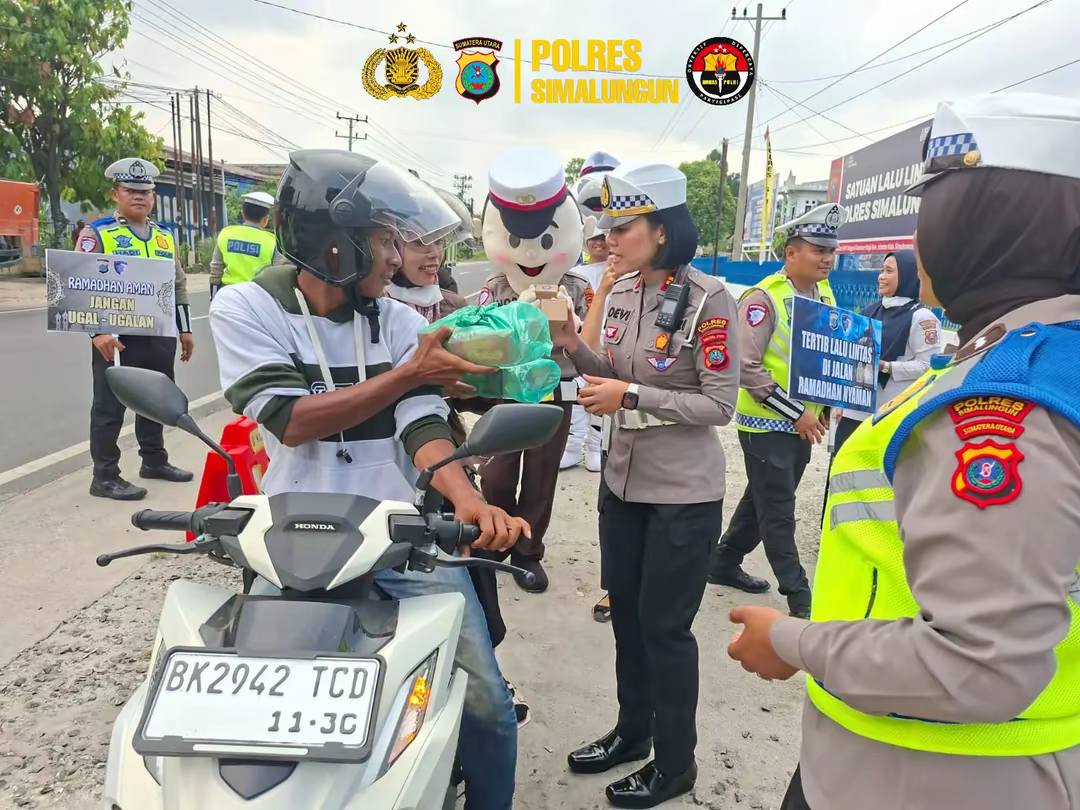 Personel Sat Lantas Polres Simalungun membagikan takjil dan bingkisan kepada pengguna jalan di depan Mako Sat Lantas menjelang waktu berbuka puasa.