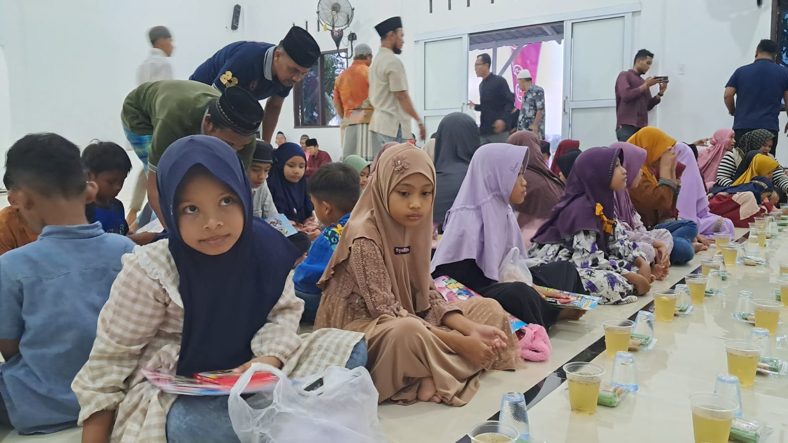 Anak-anak duduk di dalam Musala Al Ikhlas, Desa Bukit Rata, Kecamatan Kejuruan Muda, Aceh Tamiang, menunggu waktu berbuka puasa bersama usai kegiatan keagamaan dalam program Surau Kita Berdaya IOH.
