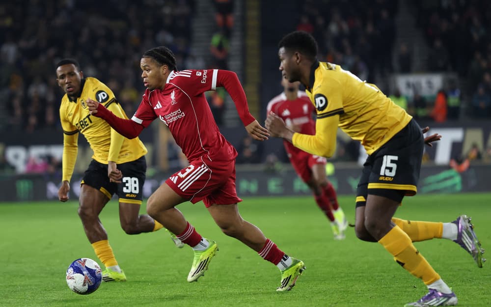 Pemain Liverpool Alexis Mac Allister berusaha melewati pemain Wolverhampton Wanderers dalam laga putaran kelima Piala FA di Molineux Stadium. Skor babak pertama masih 0-0.