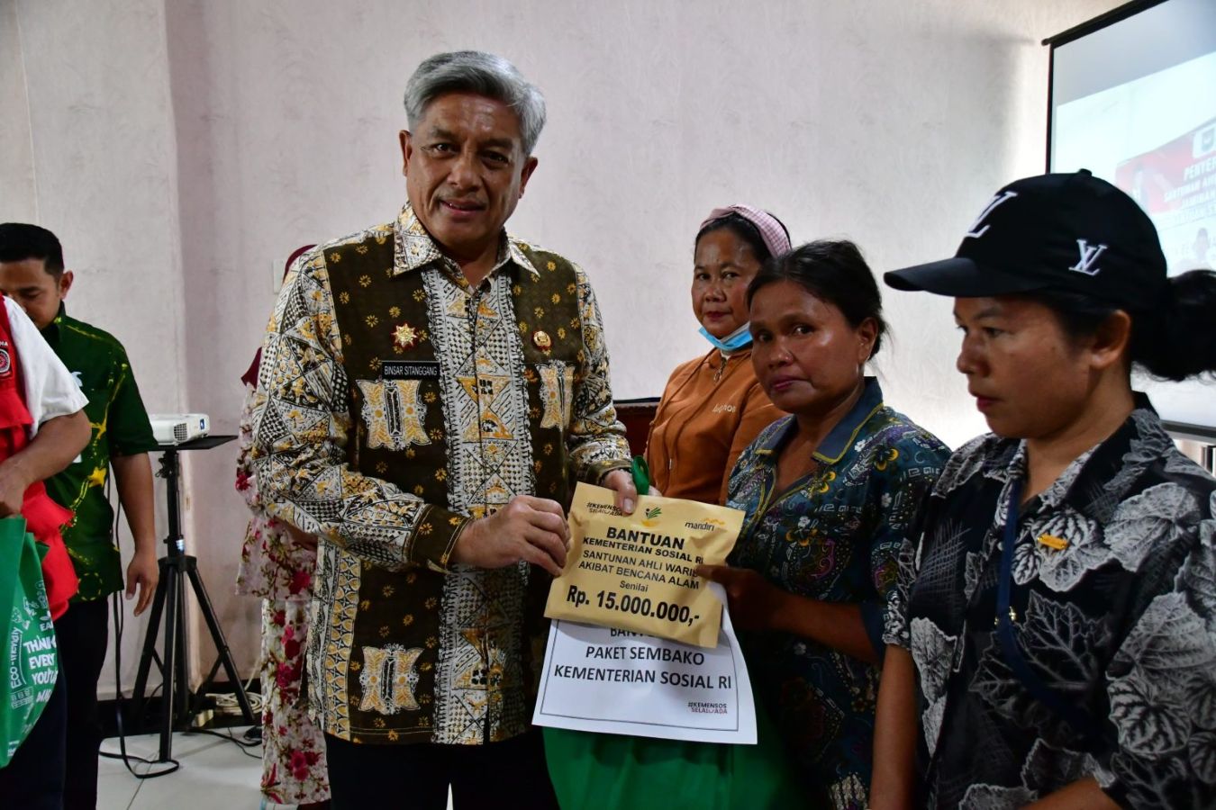 Sekda Tapanuli Tengah Binsar Sitanggang menyerahkan santunan kepada ahli waris korban banjir bandang dan tanah longsor di Pia Hotel Pandan.