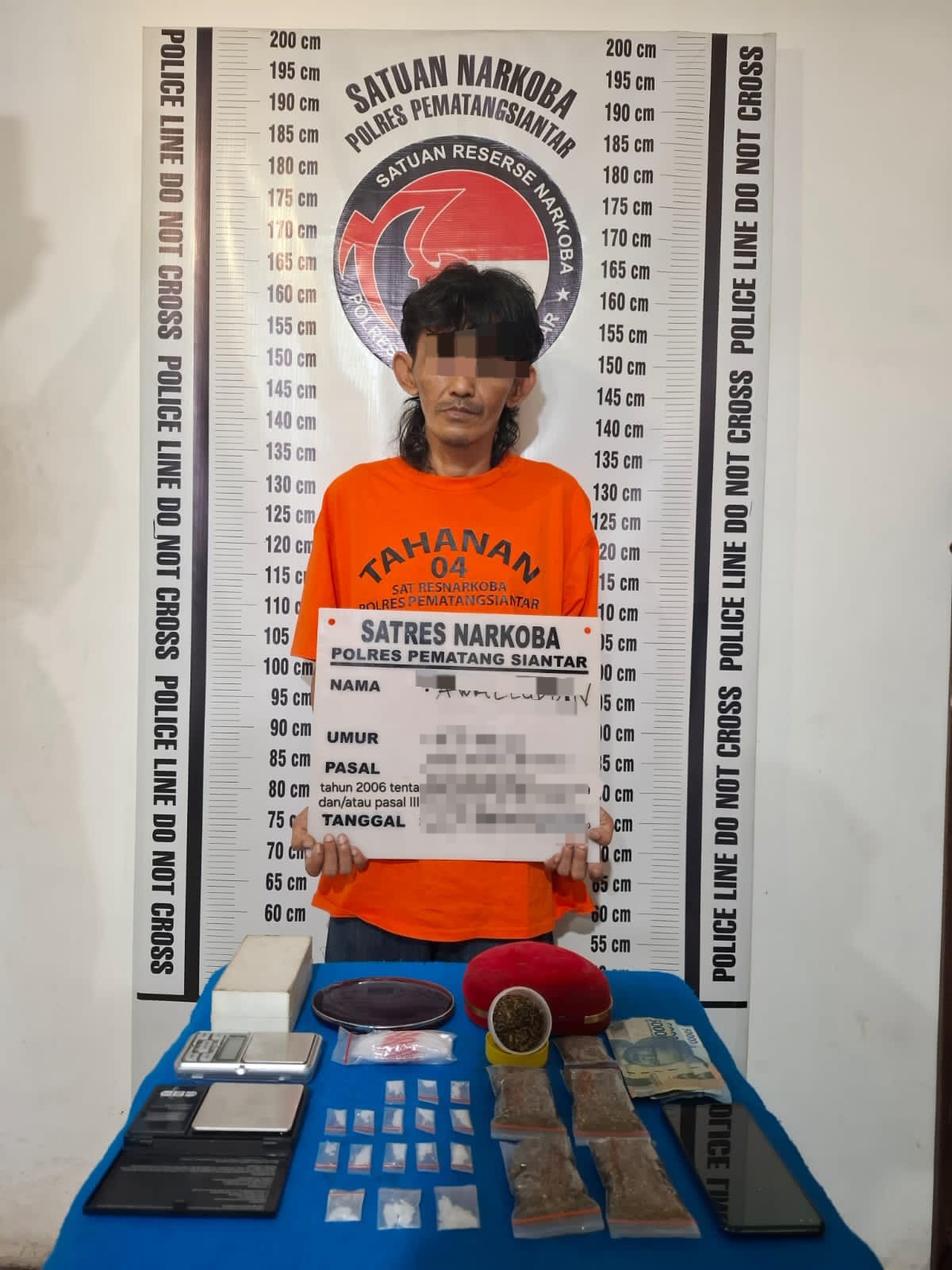 Petugas Sat Resnarkoba Polres Pematangsiantar menunjukkan sabu-sabu dan ganja hasil tangkapan Aw (47) di depan rumahnya di Jalan Purba, Siantar.