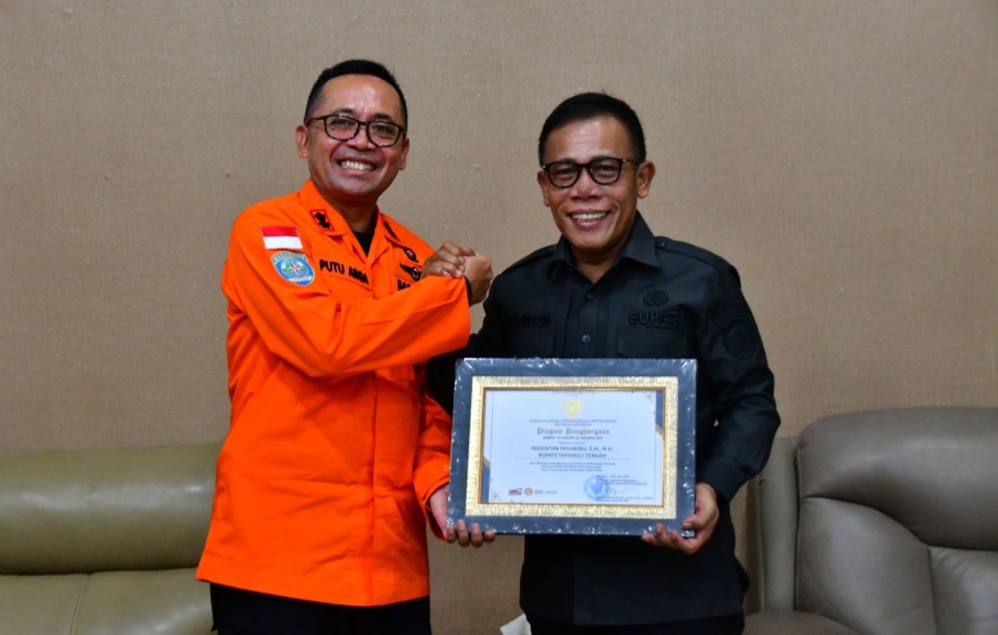 Bupati Tapanuli Tengah Masinton Pasaribu menerima piagam penghargaan dari Basarnas yang diserahkan Kepala Kantor SAR Nias Putu Arga Sujarwadi di ruang kerja Bupati Tapteng, Pandan, Selasa (10/3/2026).