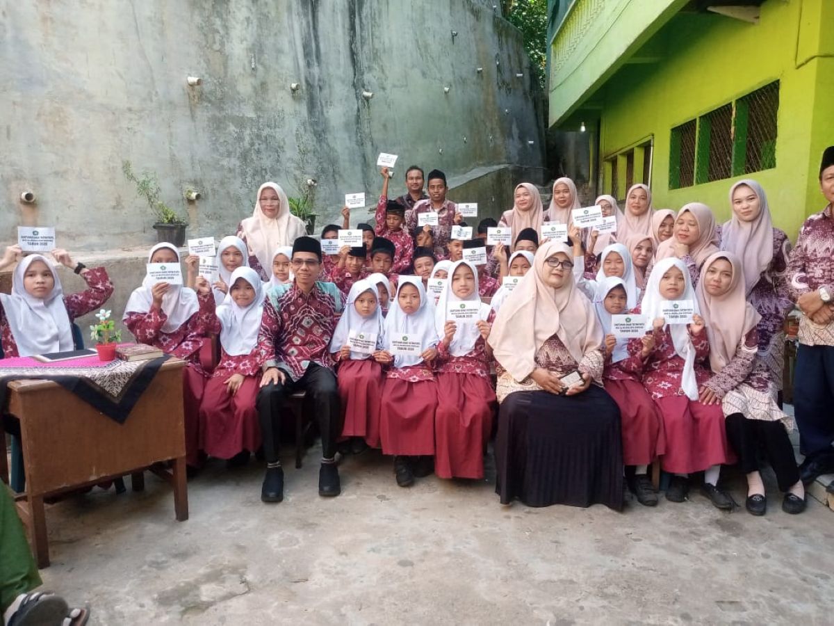 Kepala Sekolah MIS Al-Mukhlisin, Abdul Aziz, menyerahkan santunan kepada anak yatim dan piatu dalam kegiatan sosial menjelang Idul Fitri di Kota Sibolga.