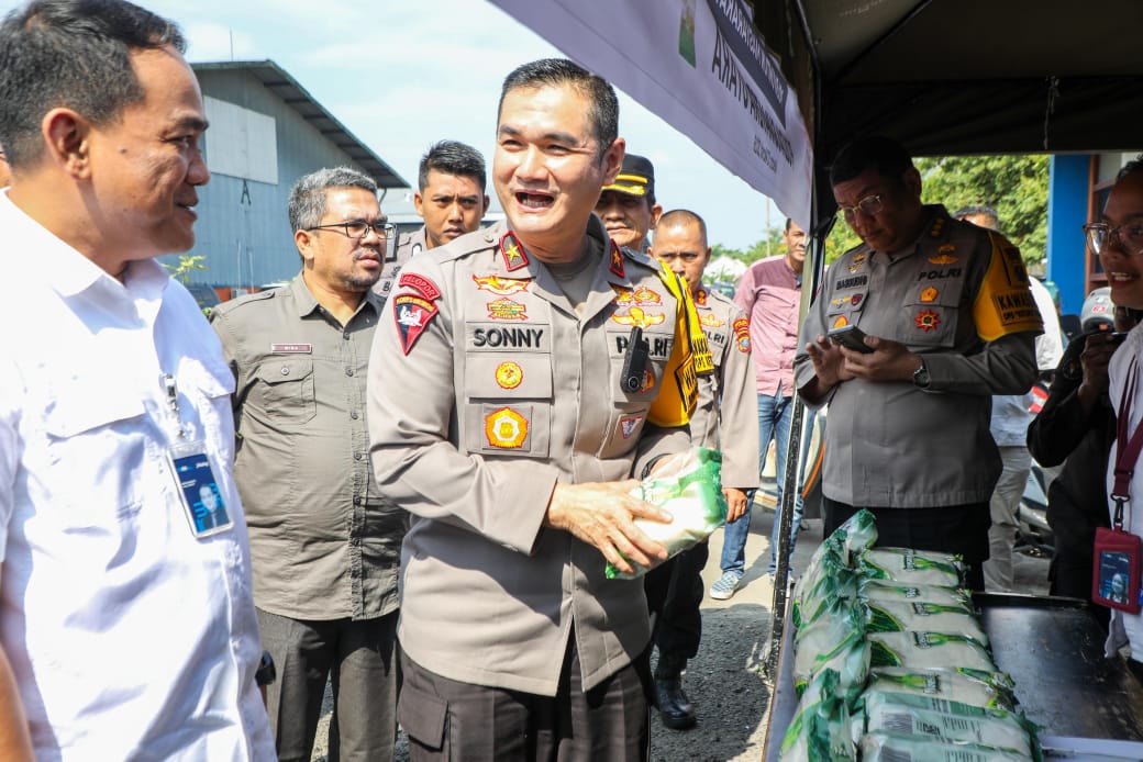 Wakil Kepala Polda Sumut Brigjen Pol Sonny Irawan bersama Pemimpin Wilayah Bulog Sumut Budi Cahyanto membagikan paket pangan murah kepada masyarakat di Medan, Jumat (13/3/2026).