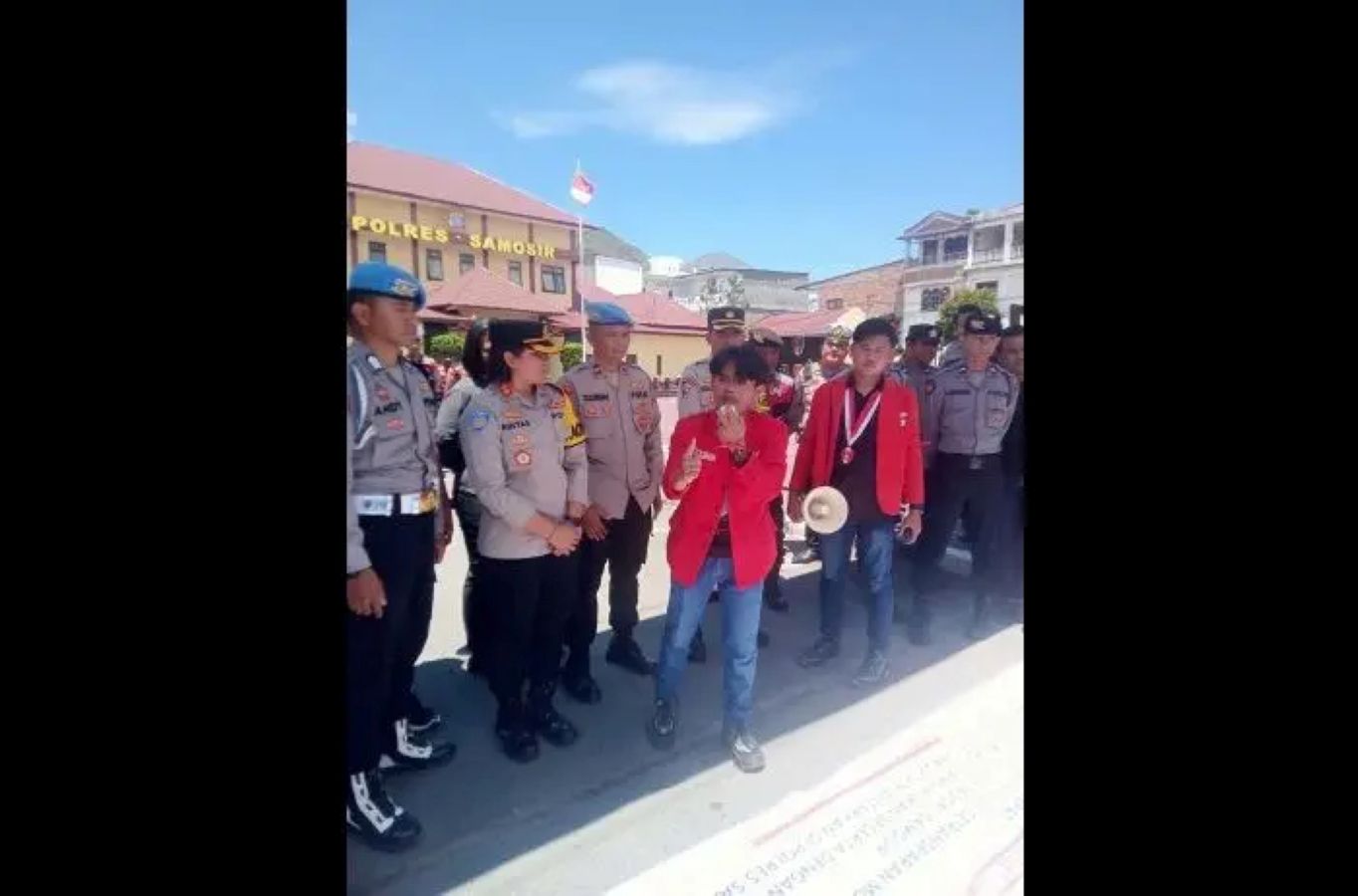 Massa dari Gerakan Mahasiswa Nasional Indonesia bersama warga Kabupaten Samosir menggelar aksi unjuk rasa di depan Polres Samosir menuntut pengusutan tuntas kematian Army Siregar di Lapas Pangururan.