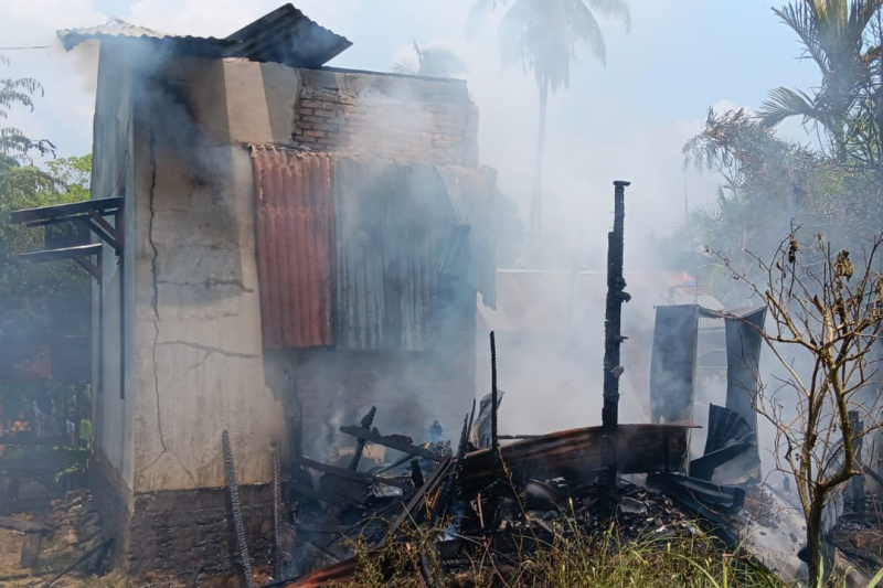 Petugas dan warga berupaya memadamkan rumah yang terbakar di Desa Darussalam, Kecamatan Panyabungan, Mandailing Natal.