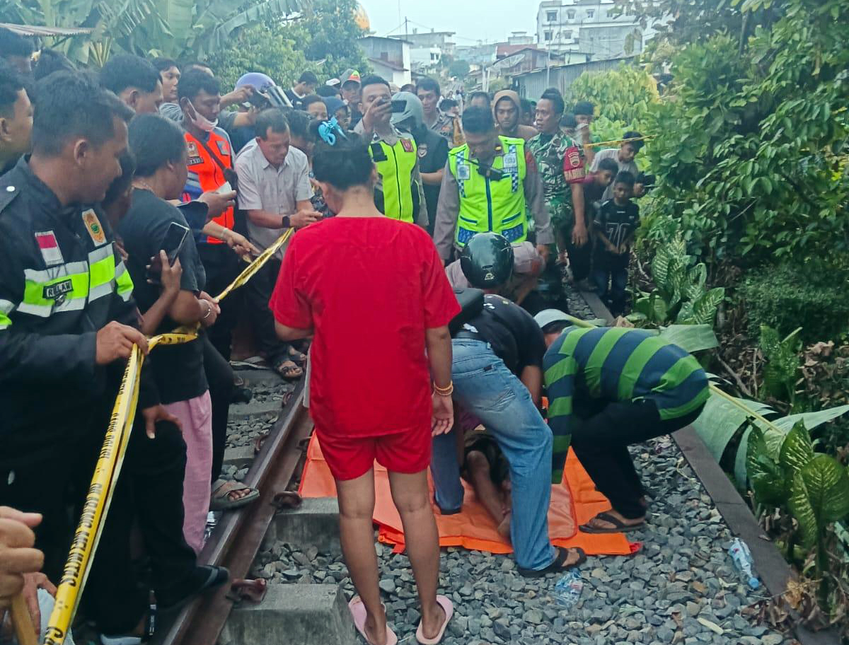 Petugas mengevakuasi jenazah wanita yang tewas tertabrak kereta api di perlintasan rel di Kota Pematangsiantar.