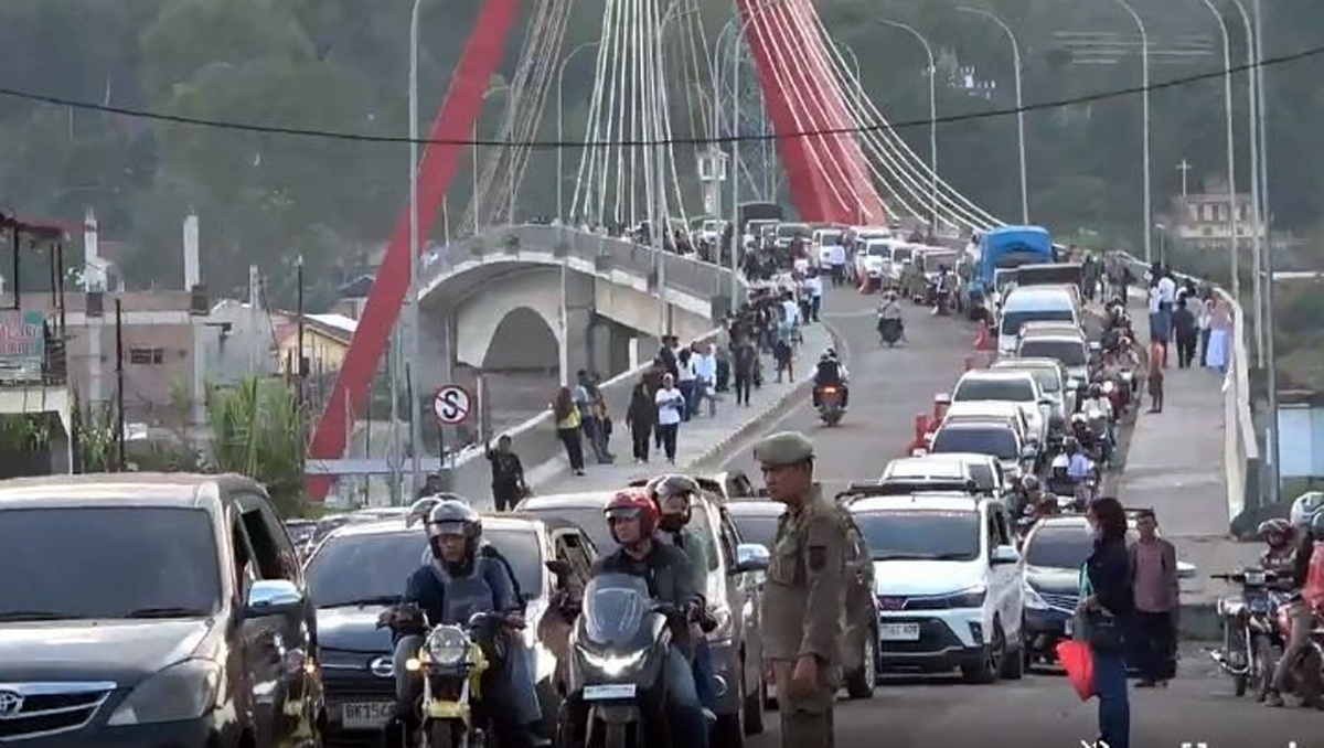 Petugas Polres Samosir menerapkan sistem one way di kawasan wisata untuk mengurai kemacetan akibat lonjakan wisatawan saat libur Lebaran.
