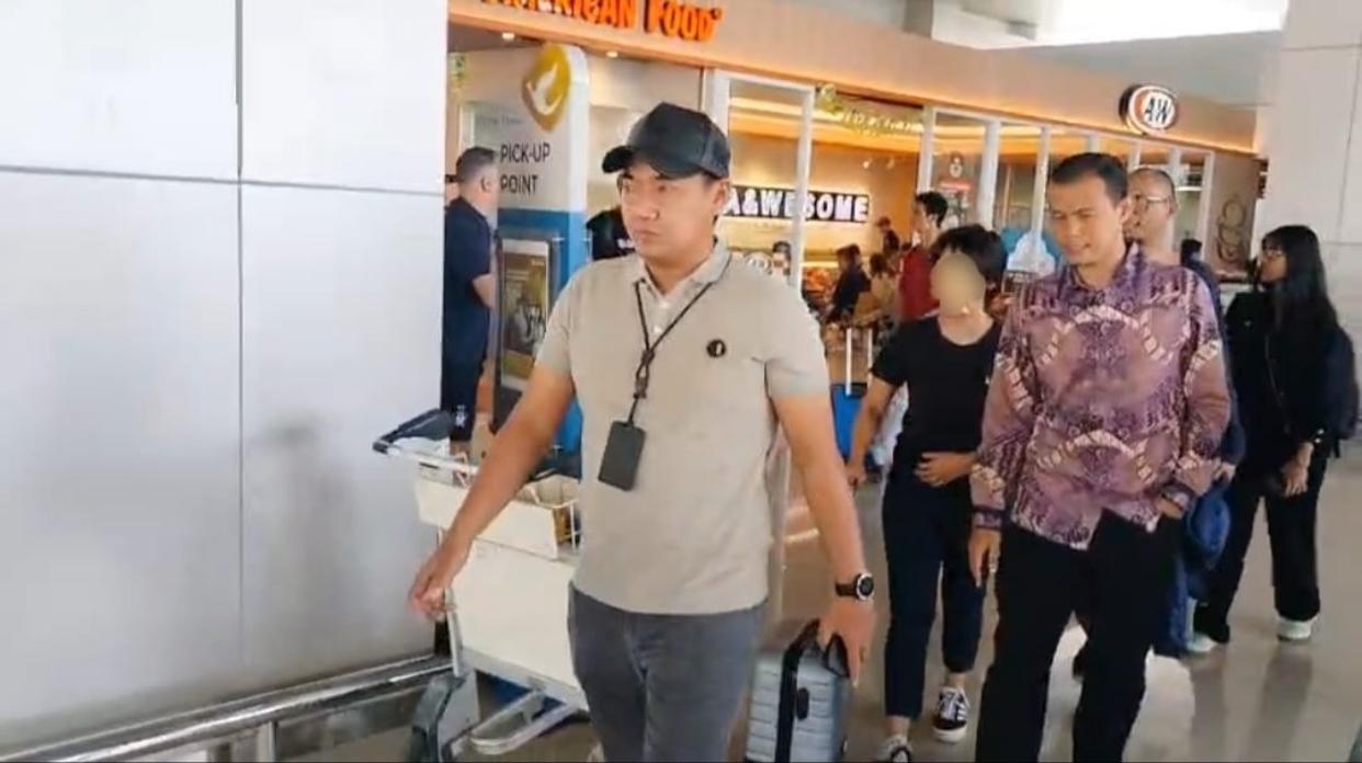 Petugas mengamankan tersangka kasus dugaan tindak pidana perbankan di Stasiun Gambir sebelum dibawa ke Surabaya untuk pemeriksaan.