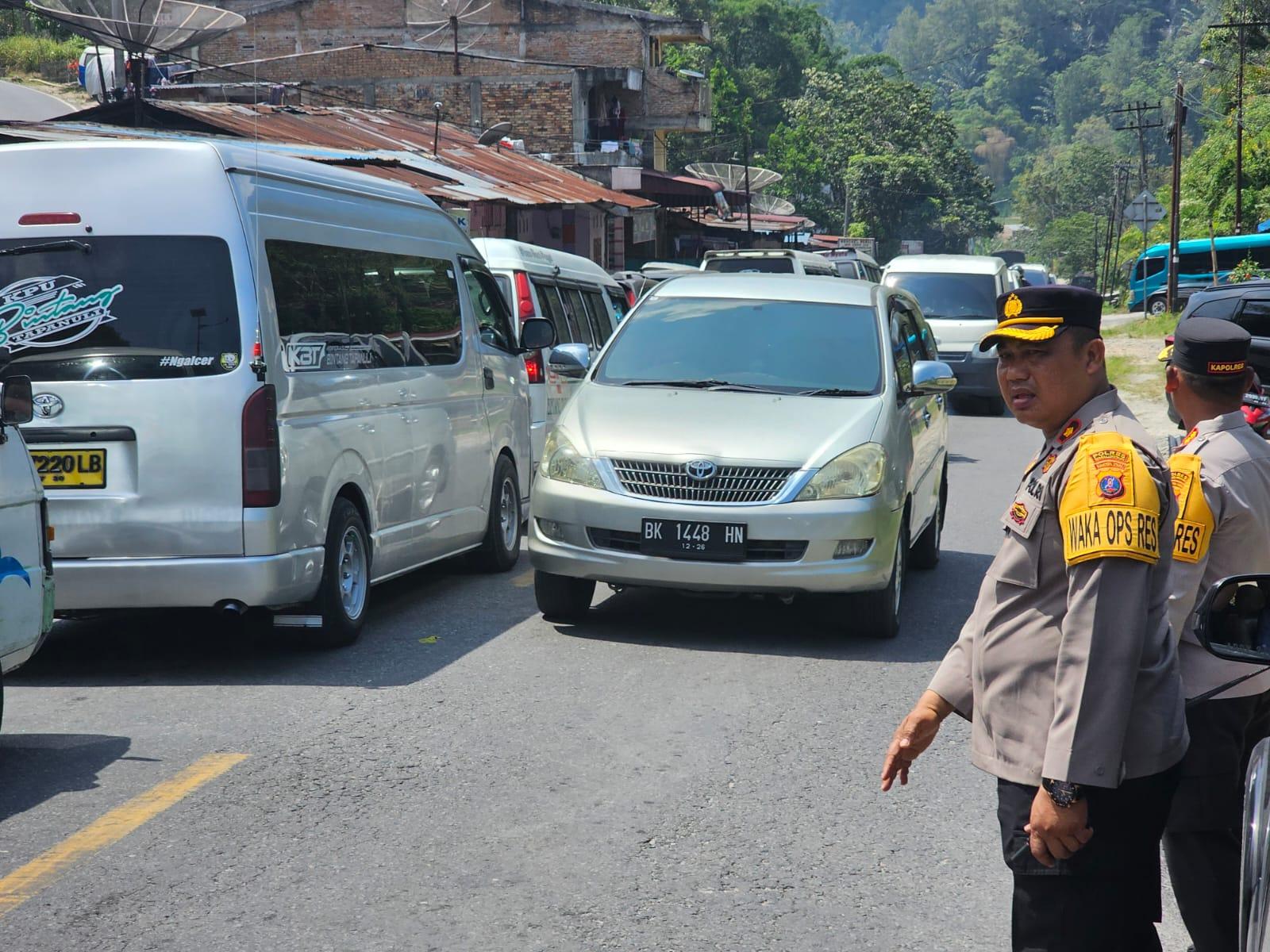 Kepadatan kendaraan di jalur Toba-Parapat saat arus balik Lebaran, polisi turun langsung mengatur lalu lintas untuk mengurai kemacetan.
