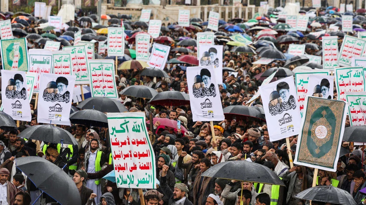 Pendukung Houthi membawa poster pemimpin Iran dalam aksi di Sanaa, Yaman, di tengah meningkatnya tensi konflik yang berpotensi mengganggu jalur pelayaran global.