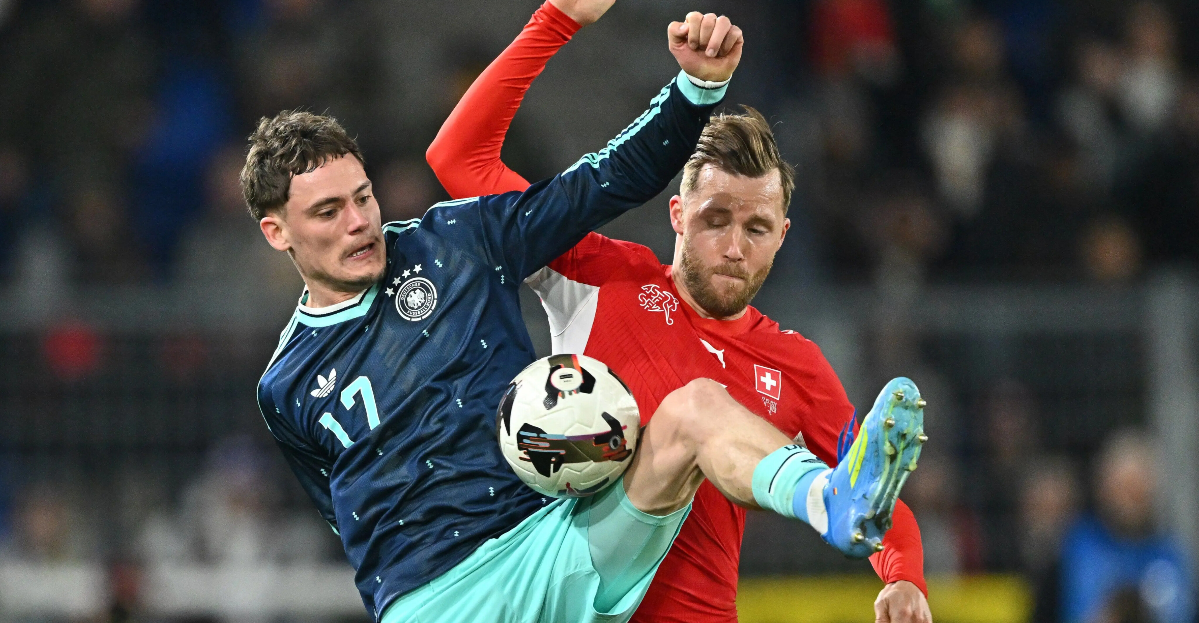 Florian Wirtz berebut bola dengan pemain Swiss dalam laga uji coba di Basel, Sabtu (28/3/2026) dini hari WIB.