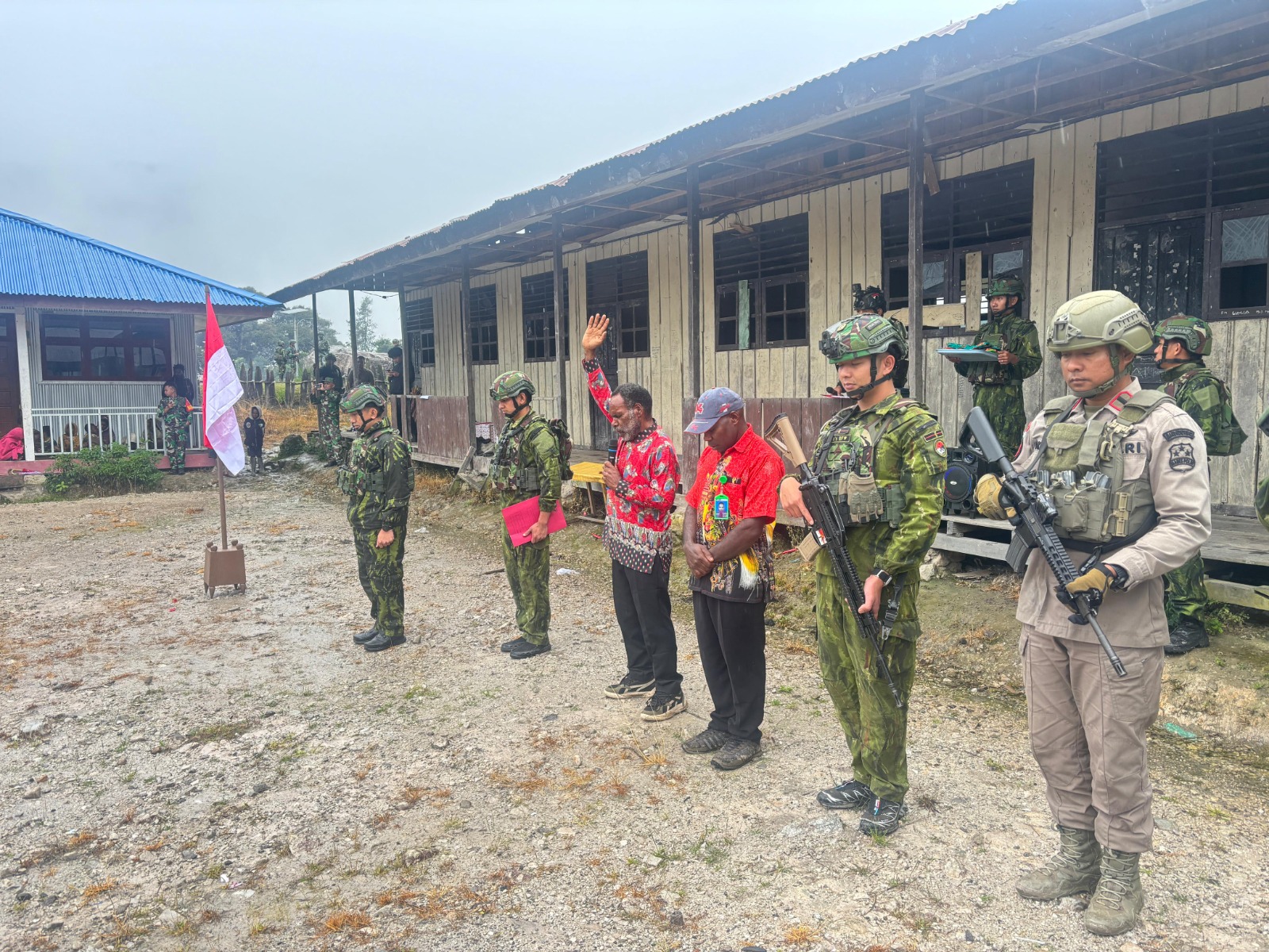 Tiga eks anggota kelompok bersenjata mencium bendera Merah Putih usai mengucapkan ikrar setia kepada NKRI di Distrik Sinak, Kabupaten Puncak, Papua Tengah.