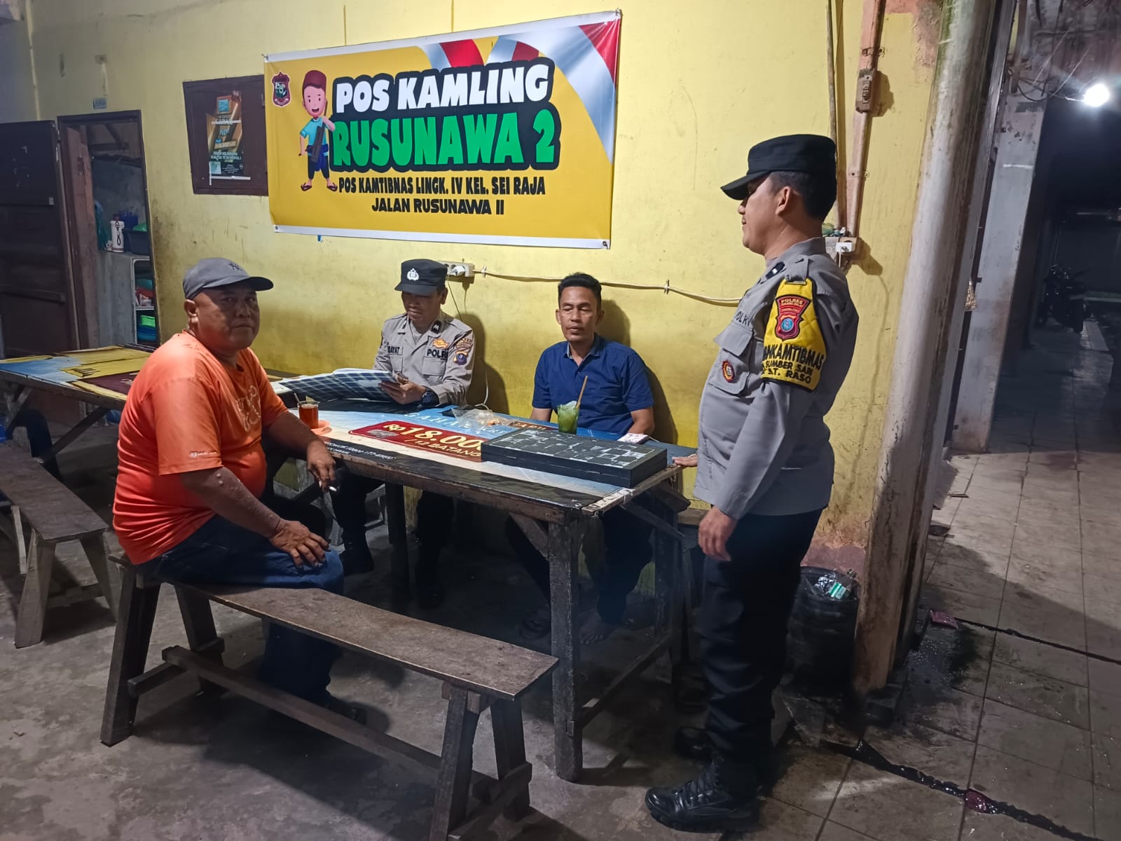 Personel Polsek Sei Tualang Raso berdialog dengan warga saat menyambangi pos kamling guna memperkuat ronda malam di Tanjungbalai.