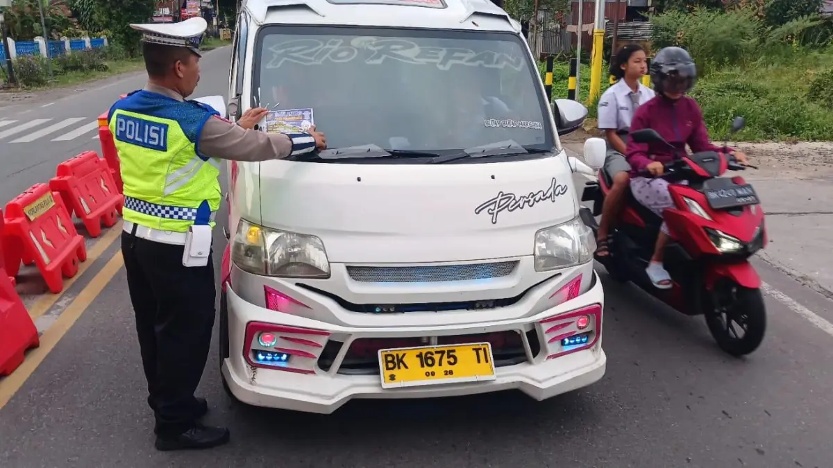Personel Sat Lantas Polres Pematangsiantar membagikan brosur tertib berlalu lintas kepada pengguna jalan di Kota Pematangsiantar.