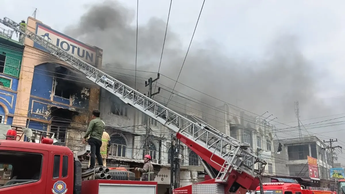 Petugas pemadam kebakaran dibantu personel kepolisian memadamkan api yang melahap toko cat di Jalan Marelan Raya, Medan Marelan, Kamis (9/4/2025). Kebakaran menewaskan satu orang.
