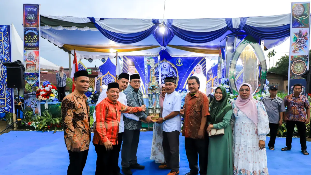 Perwakilan Kelurahan Sumber Jaya menerima trofi juara umum MTQN ke-58 Tingkat Kecamatan Siantar Martoba Tahun 2026 di Kota Pematangsiantar.