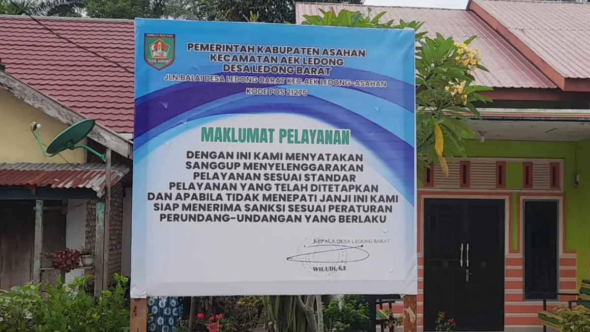 Plang maklumat pelayanan terpasang di depan Kantor Desa Ledong Barat, Kecamatan Aek Ledong, Kabupaten Asahan, sebagai bentuk komitmen peningkatan layanan publik. 