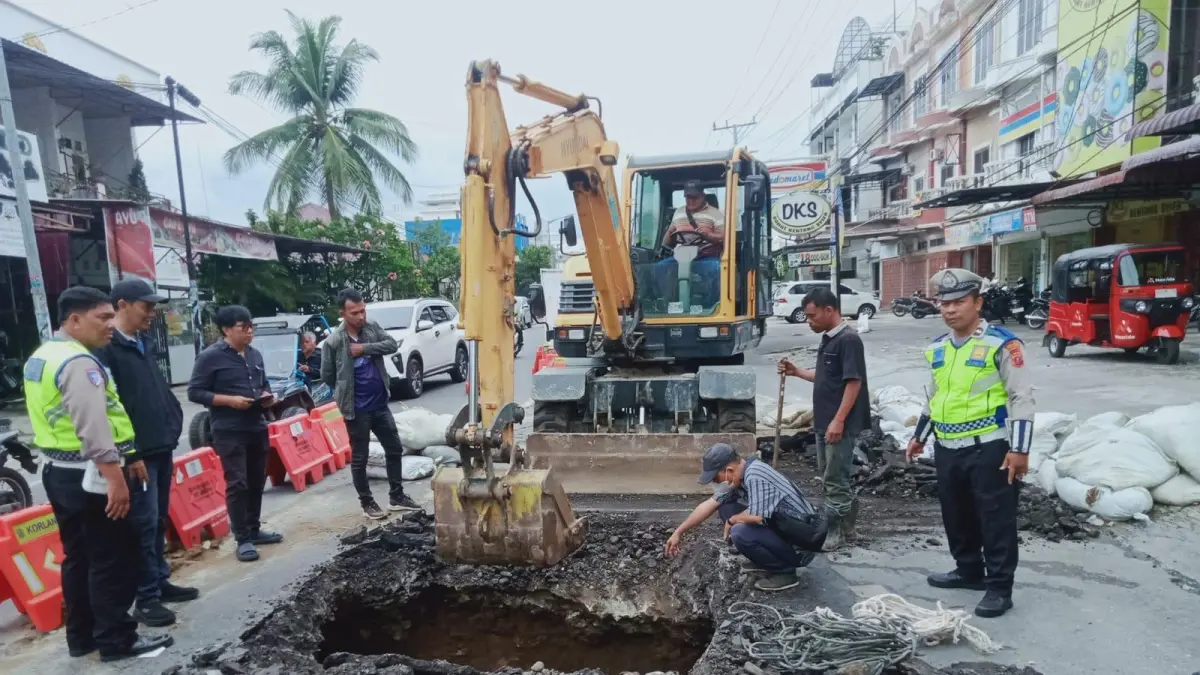 Petugas melakukan perbaikan ruas Jalan Gereja di Pematangsiantar yang amblas akibat gorong-gorong tersumbat sampah berupa sprei dan kasur.