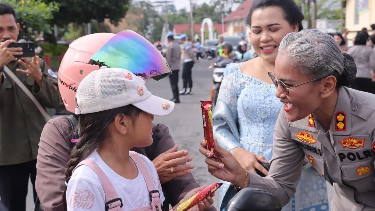 Kapolres Pematangsiantar AKBP Sah Udur Togi Marito Sitinjak membagikan cokelat kepada pengendara dalam peringatan Hari Kartini 2026.