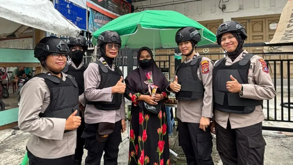 Srikandi Polwan Polres Pematangsiantar membagikan bunga dan cokelat kepada masyarakat saat patroli dialogis di Hari Kartini.